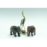 Two carved wooden elephants, 11cm, together with a stork, 26 cm