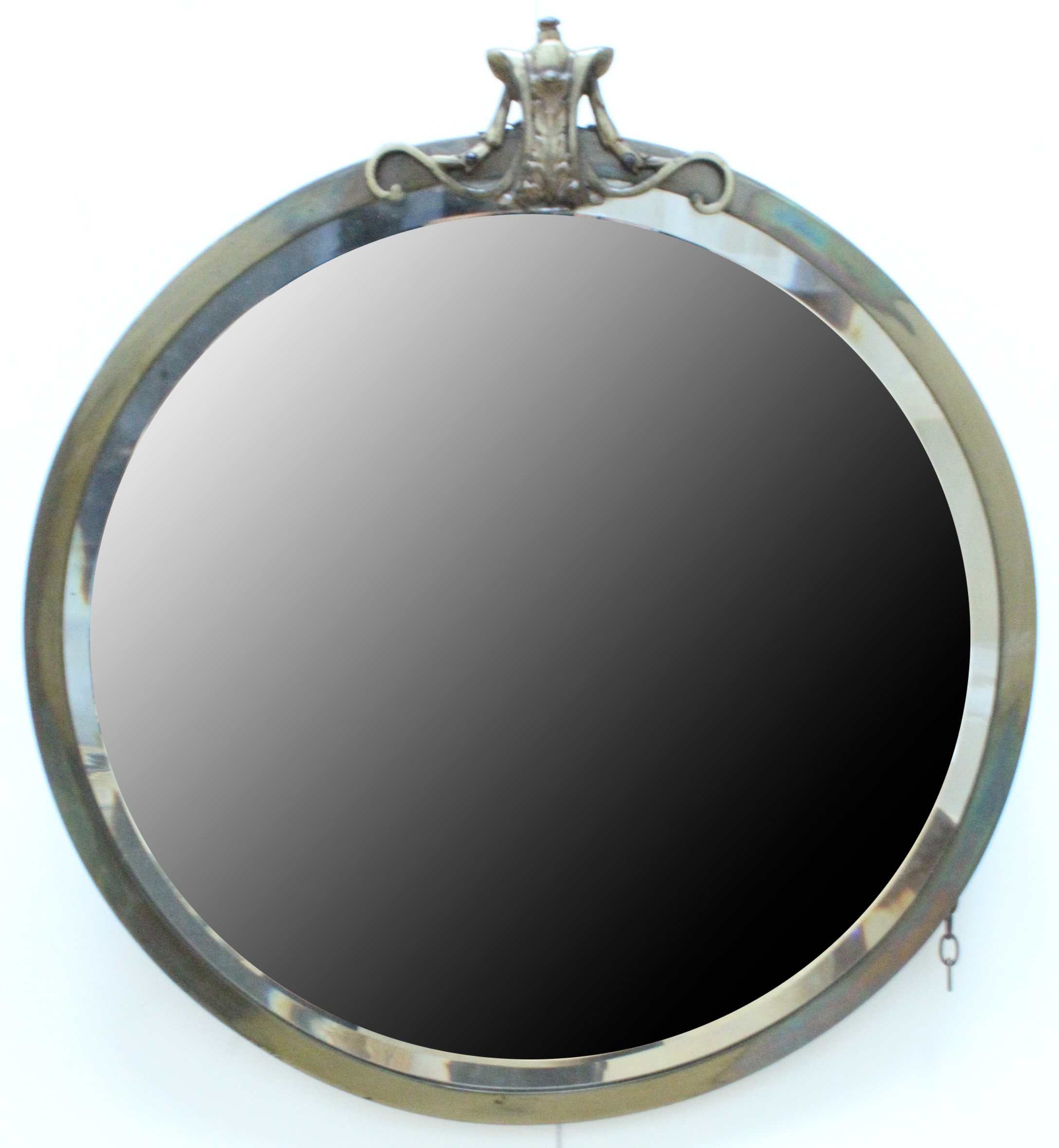 A 1930s circular brass framed wall mirror, the frame of plain square form with a cast brass crest,