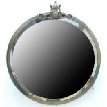 A 1930s circular brass framed wall mirror, the frame of plain square form with a cast brass crest,