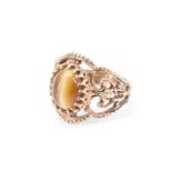 A 1970s 9 ct gold tiger's eye ring, having a 7.5 x 9.5 mm oval tiger's eye cabochon set on broad