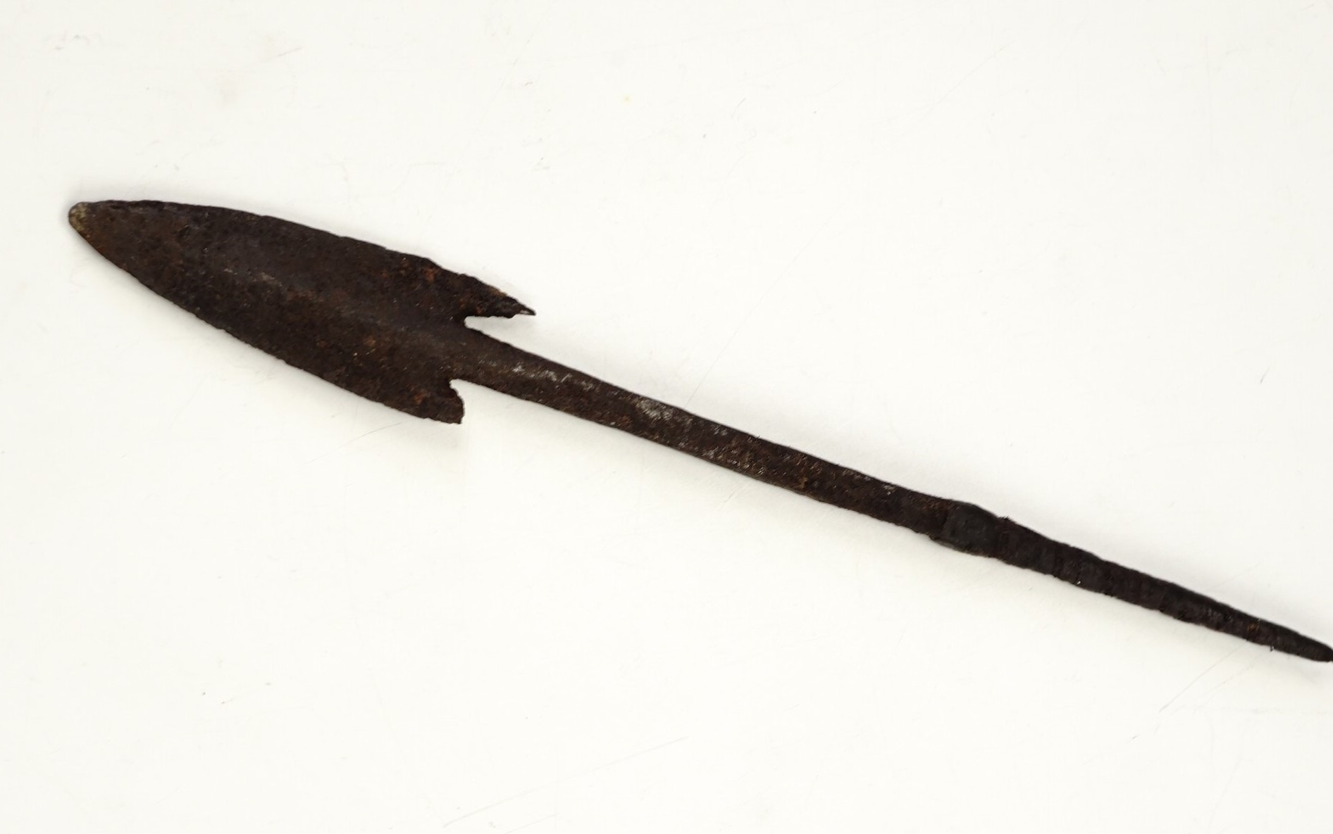A medieval iron spear or arrow head, of barbed and tanged form, 18 cm