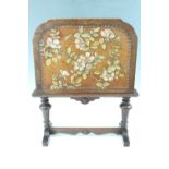 An early 20th Century Carolean Revival oak low screen, having a tooled and painted hide insert