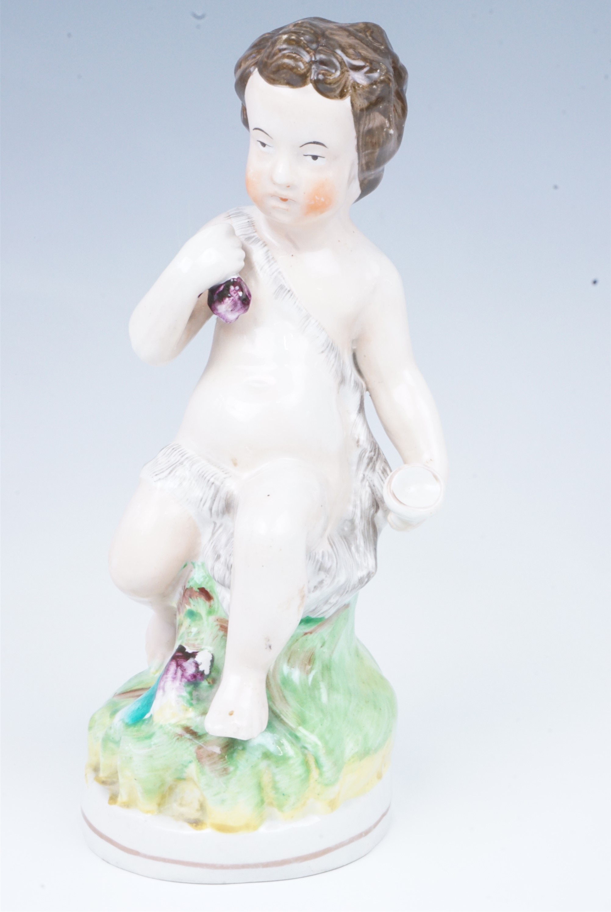 A late 19th Century Staffordshire figurine of a putto, 23.5 cm