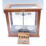 An analytical balance by River Chemical Company Ltd, together with a cased set of early 20th Century