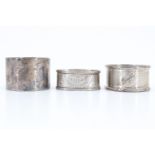 Three silver napkin rings, comprising a Victorian oval ring, having bright cut decoration,