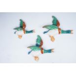 A trio of wall hanging flying ducks, largest 24 cm