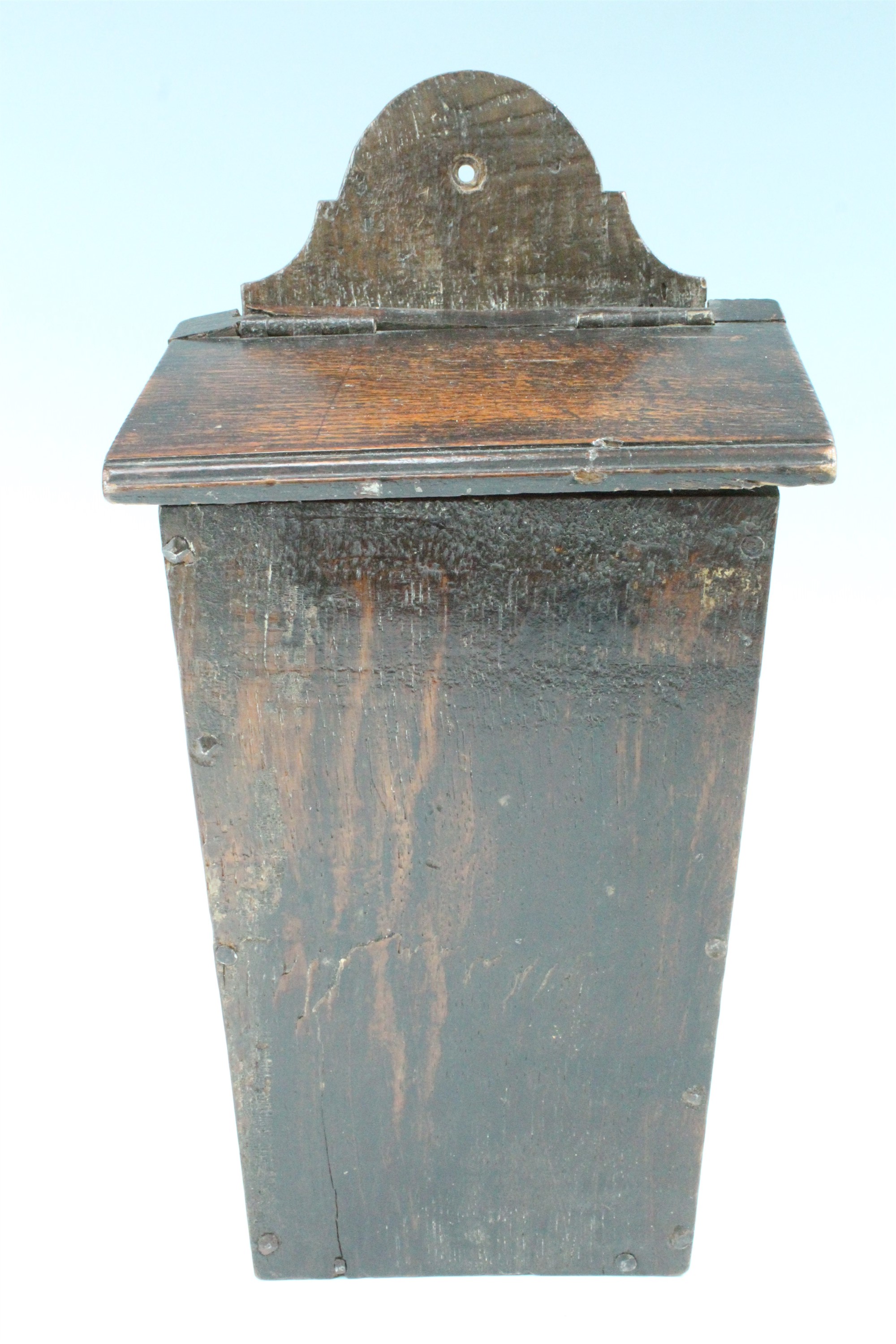 An early 19th Century provincial oak candle box, of tapering vertical form with a hinged lid, of
