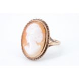 A shell cameo 9 ct gold finger ring, having a rope moulded edge and open trifurcated shoulders,