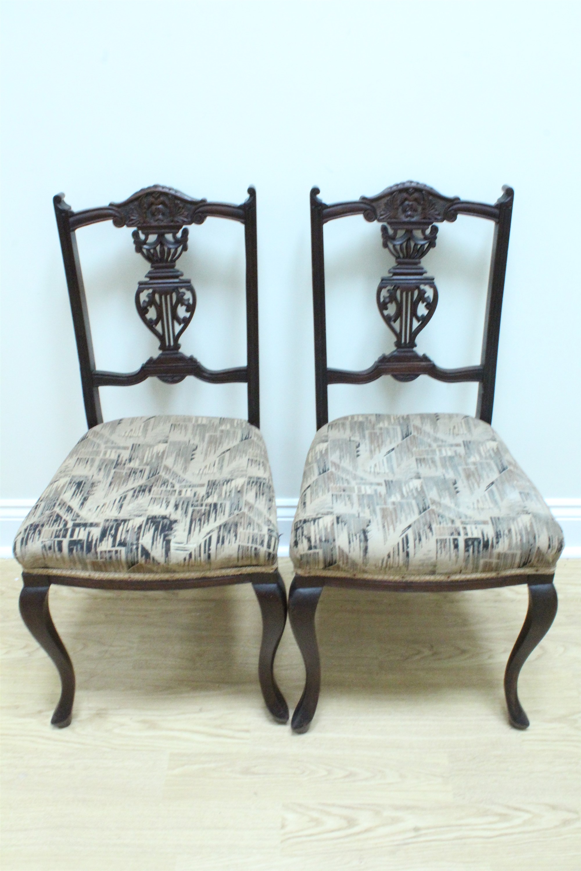 A pair of late 19th Century upholstered and carved mahogany salon standard chairs