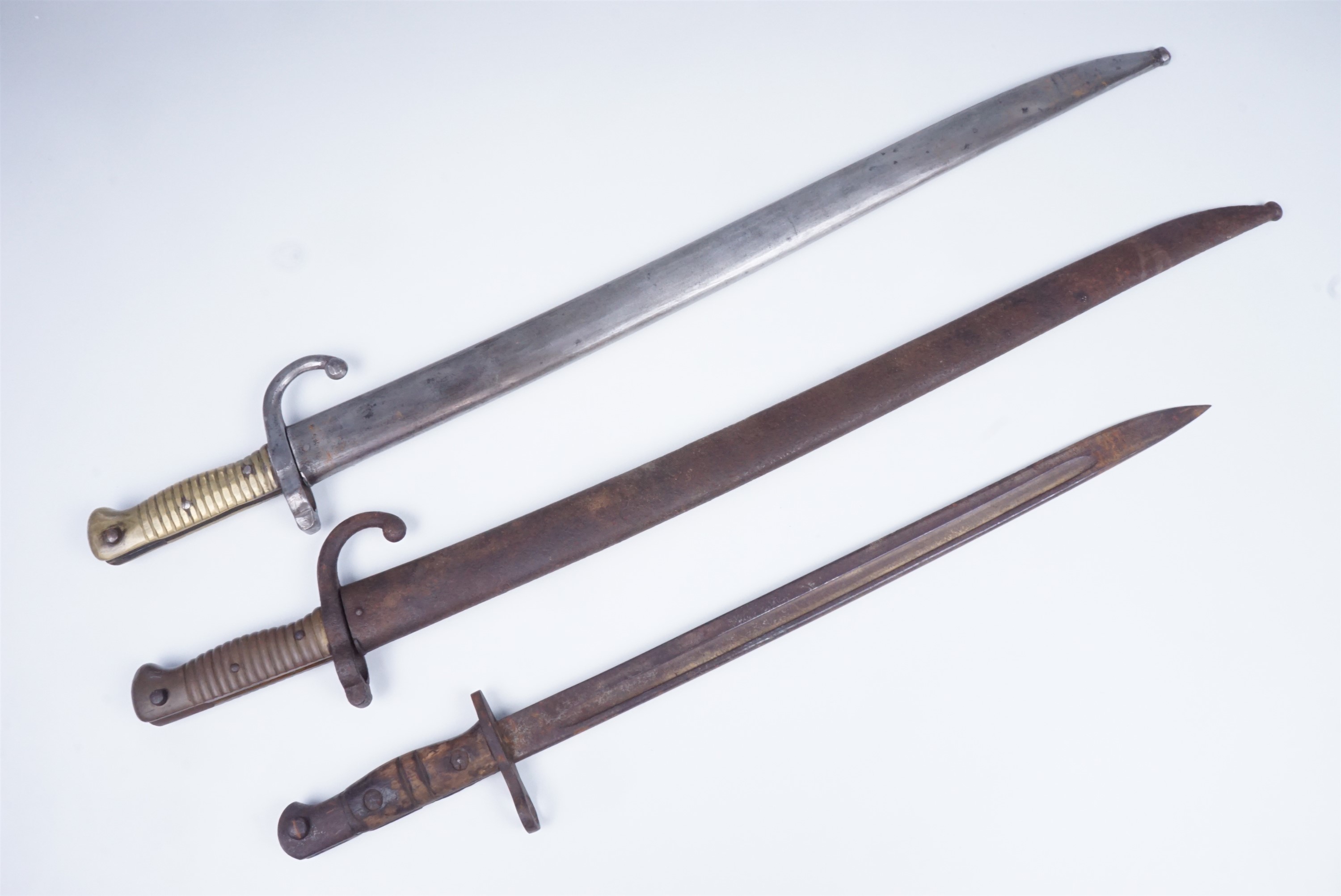 Two French Mle 1866 bayonets together with a British Pattern 1913 bayonet (lacking scabbard)