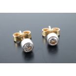 A pair of diamond stud earrings, comprising 0.1 ct diamond brilliants bezel set on 18 ct white and