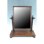 An Early 19th Century mahogany toilet mirror, having a platform base on pad feet, and turned