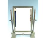 A late 20th Century brass toilet mirror, having cast brass square pedestal bases and turned