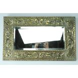 A 1930s brass framed bevel-edged mirror, the frame being decorated with embossed scrolling acanthus,