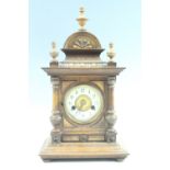 Early 20th Century German walnut mantle clock, striking on a gong with a turned columns and finials,