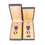 Two US Purple Heart medals, cased