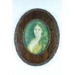 A pair of unusual Edwardian oval oak frames, displaying two later pre-raphaelite prints, the