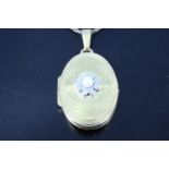 A 9 ct pearl diamond and gold oval locket, the front set with a flower formed from a 3 mm pearl