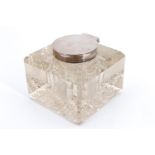 An Edwardian silver mounted cut glass inkwell, of square form having a hob cut base and hinged