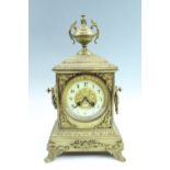 An ornate early 20th Century cast brass mantle clock, having a French drum movement striking on a