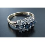 A diamond and sapphire 9 ct gold ring, having a line of five graduated brilliant cut sapphires (