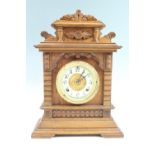 An Ansonia eight day American carved oak mantle clock, striking on a gong, key present, 32 x 14 x 44