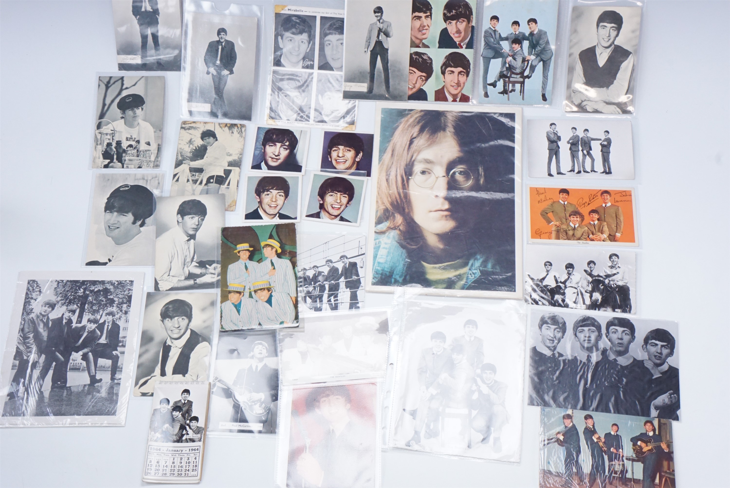 A group of The Beatles promotional photographs, postcards, a band calendar etc, circa 1960s