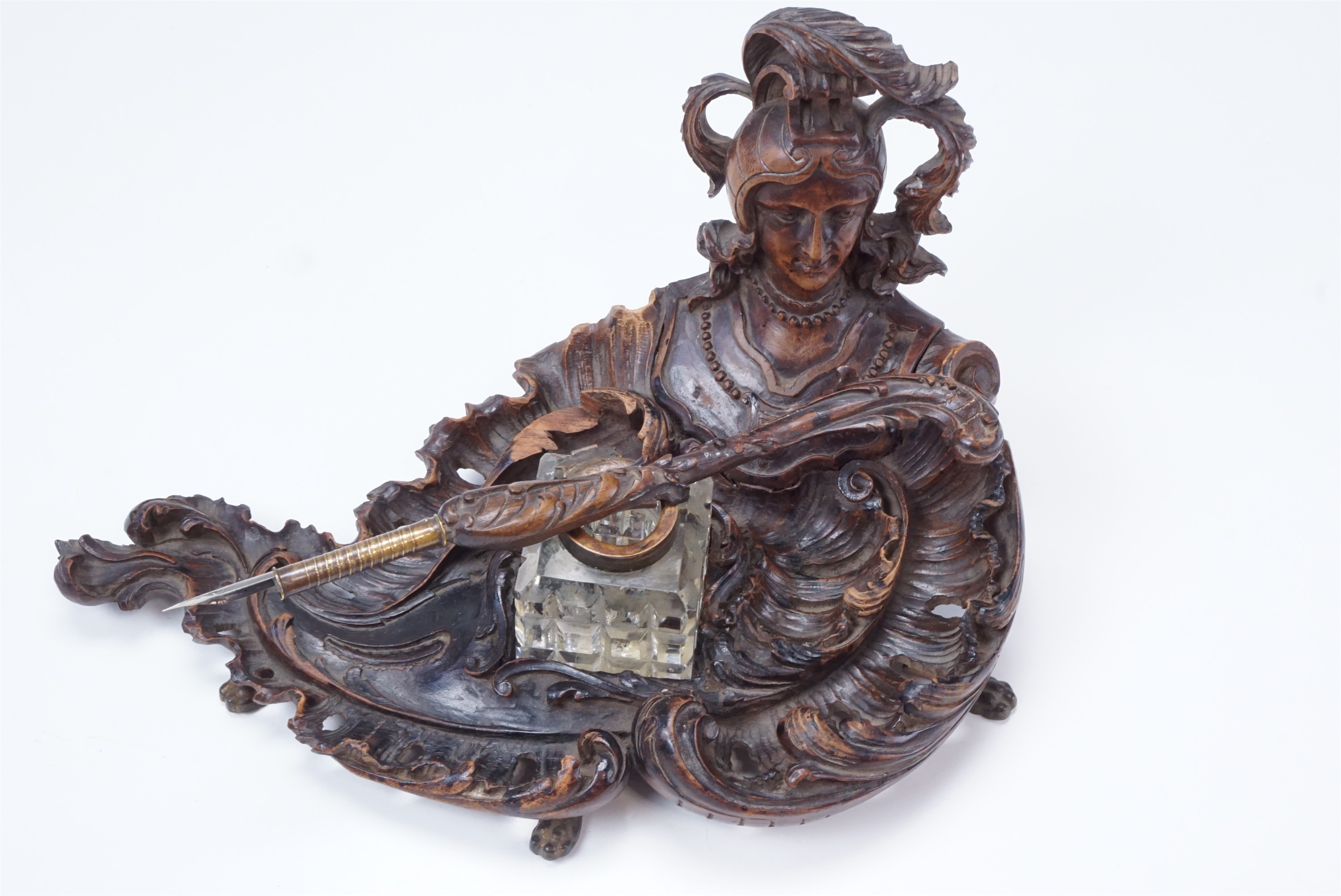 A finely carved late 19th / early 20th Century walnut ink standish, of rococo form having a helmeted