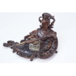 A finely carved late 19th / early 20th Century walnut ink standish, of rococo form having a helmeted