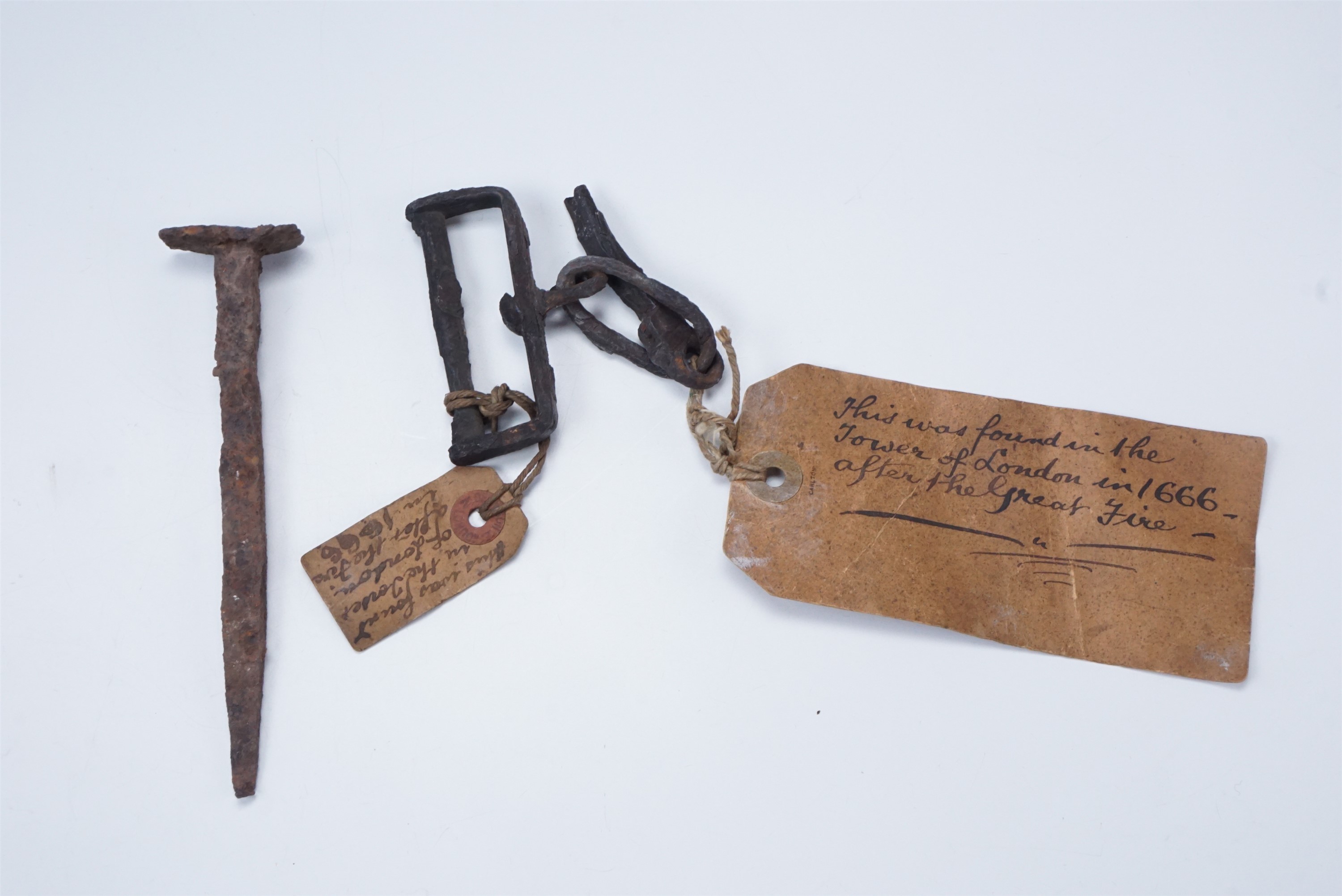 A wrought iron relic bearing inscribed labels stating it was found at the Tower of London in 1666