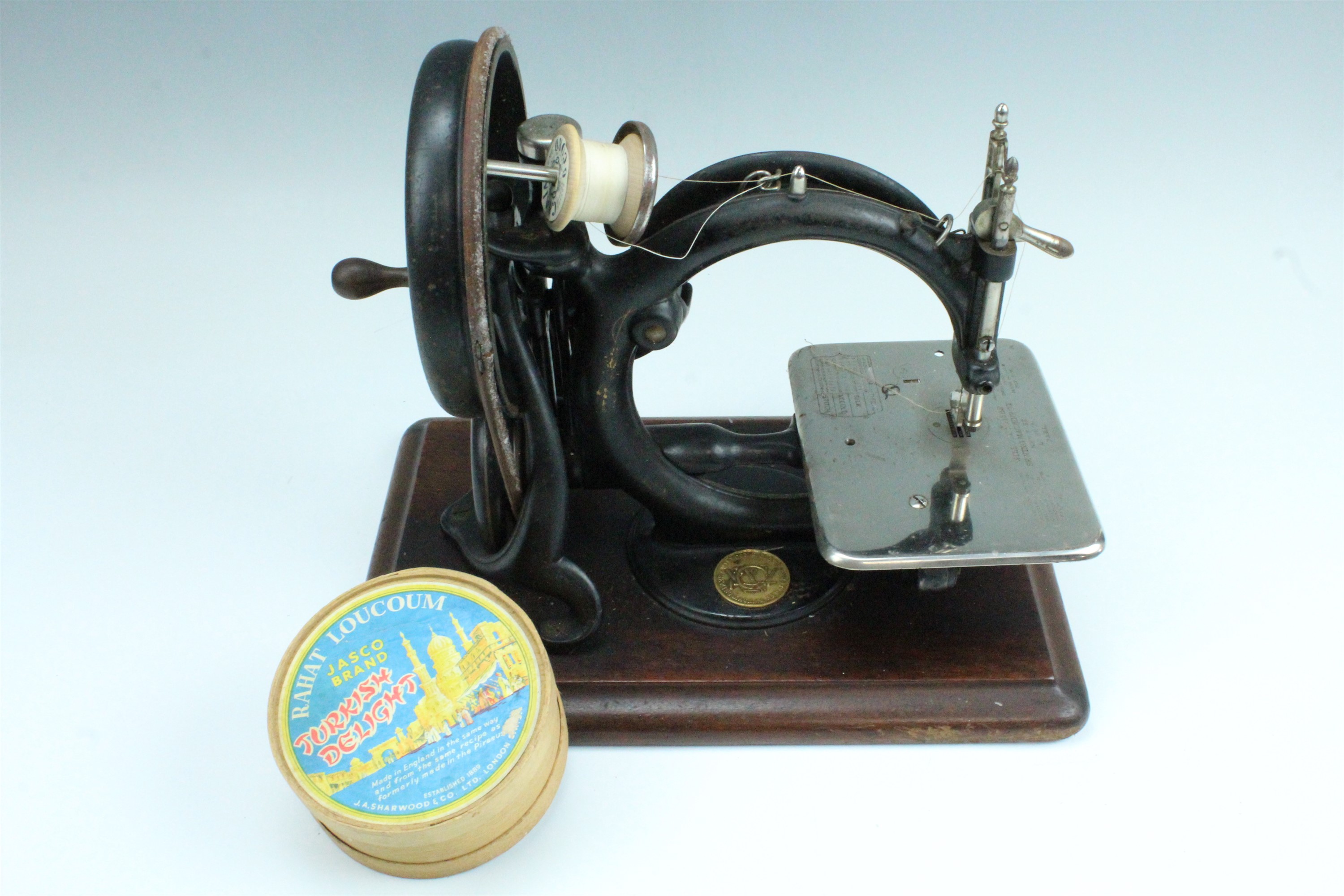 A late 19th Century Willcox and Gibbs cat back hand sewing machine, in original brass bound pine