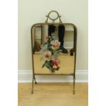 A belle epoque brass framed mirror fire screen, the bevelled mirror having a later painted floral