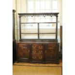 An 18th Century Cumberland oak dresser, having fielded panelled doors and fluted architectural
