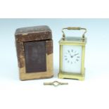 [Great War] An George V brass carriage clock in leather travel case, the top of the corniche clock