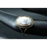 A 1970s 9 ct gold shell cameo ring in the form of a rose, bezel set having a rope twist border on