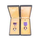 Two US Purple Heart medals, cased