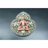 An antique Nepali Hindu brooch, set with carved coral and turquoise and centred by a