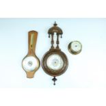 A George VI turned and carved aneroid barometer with thermometer, a 1970s beech wood barometer and