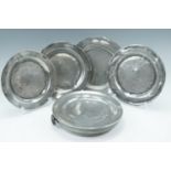 An early 20th Century pewter warming dish together with four earlier pewter plates