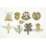 A small group of cap badges including a Control Commission Germany badge and an electroplated