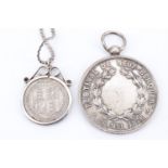 An 1889 shilling in a late 20th Century white metal coin pendant frame, on a serpentine link chain