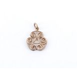 A contemporary 9 ct gold openwork pendant, comprising a trefoil arrangement of C-scrolls, 15 mm, 2.3