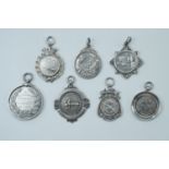 Seven silver target shooting fob medals, 1910 - 1938, including Montgomeryshire Air Gun League, 82