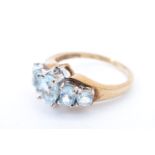 A five stone topaz ring, having a line of graduated stones, the central oval flanked by two small