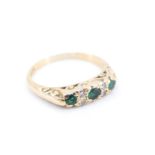 An emerald and diamond ring, comprising three emeralds divided by pairs of diamonds, the central