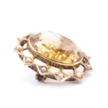 An Edwardian citrine and seed pearl brooch, the 14 x 20 mm oval stone bezel set in a yellow metal 12