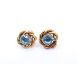 A pair of topaz and yellow metal stud earrings, each comprising a round facet-cut stone of approx