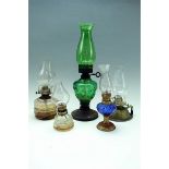 A group of Victorian and later glass oil lamps, including a emerald glass example, tallest 41 cm