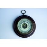 An uncommonly small late 19th / early 20th Century mahogany aneroid wheel barometer, 10 cm diameter