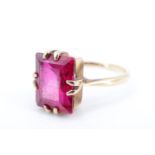 A vintage ruby cocktail ring, the baguette-cut stone of approx 4 ct, claw-set on a rectangular